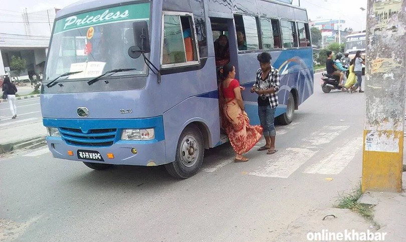 File: A conductor collects the bus fare from a passenger in Kathmandu public transport fares public bus fares