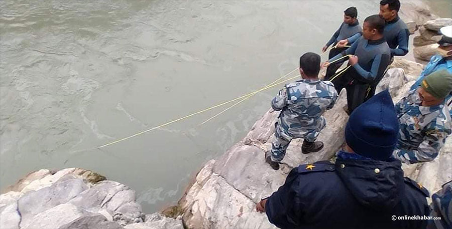 File: Security personnel searching people missing in the Trishuli river following a road accident