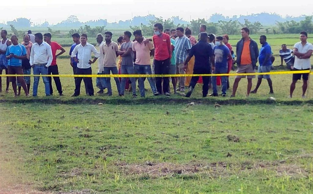 People gather when a man's body has been found after a suspected murder, in Katahari, Morang, on Sunday, May 29, 2022.